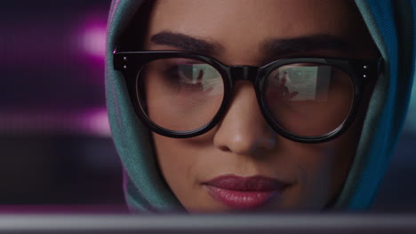 retrato en primer plano hermosa mujer de negocios musulmana usando una tableta trabajando hasta tarde navegando por internet haciendo lluvia de ideas mirando la información en la pantalla usando gafas