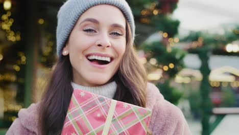 handheld view of beautiful woman shaking christmas present