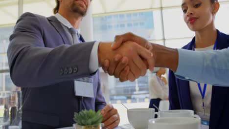 empresarios multiétnicos estrechando la mano durante un seminario 4k