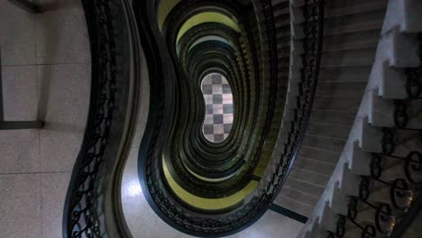 Descendiendo-Por-Escaleras-De-Caracol-En-Un-Edificio-Art-Deco-En-Brasil,-Antena-Arriba-Hacia-Abajo