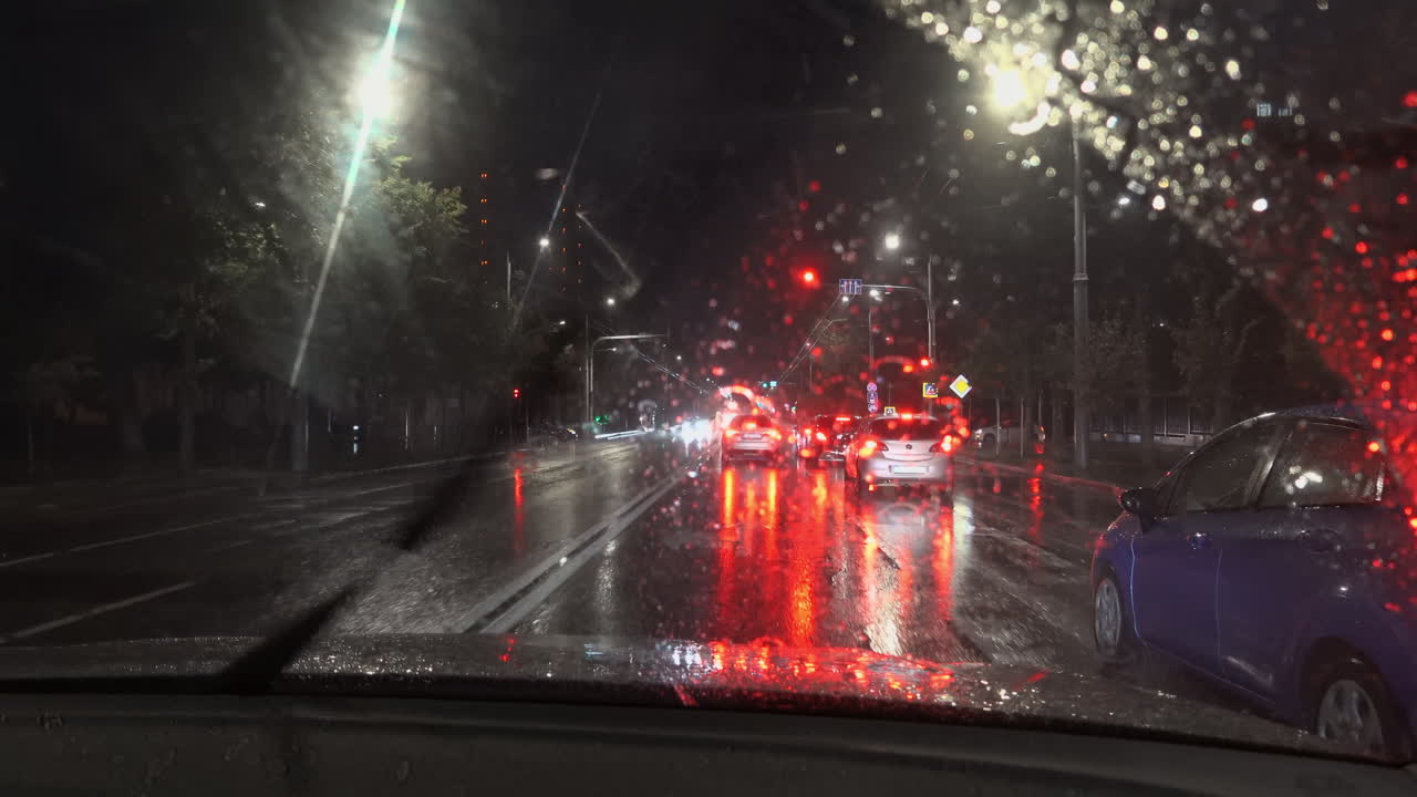 Chisinau, Moldova - June 7, 2025: View from the windshield of a moving car on the streets of the city on a rainy evening