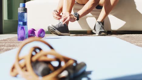 Fit-african-american-man-exercising-at-home-and-tying-the-laces