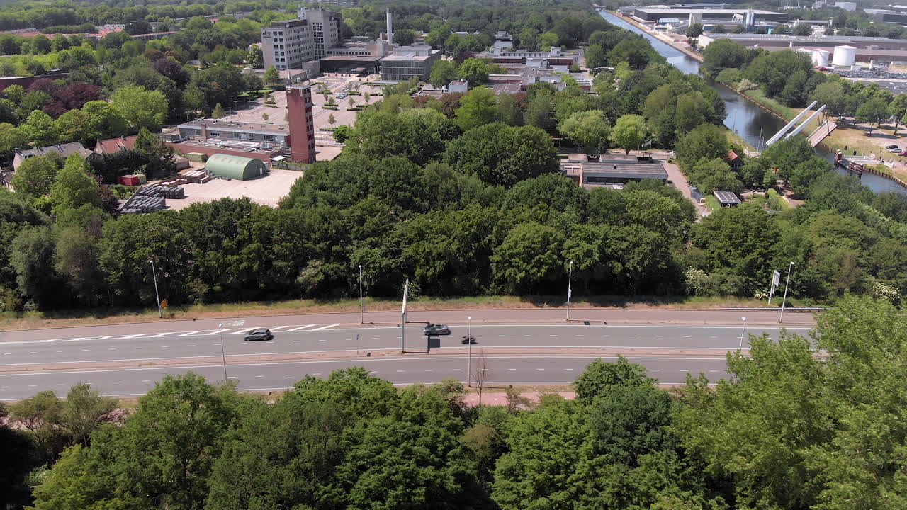 번잡한 로터리와 인접한 이웃이 있는 도시 틸부르흐 네덜란드로 향하는 도로 위를 비행하는 드론 공중 전망