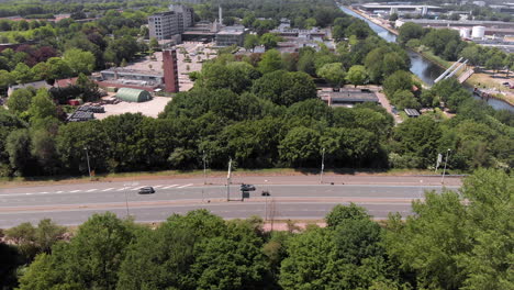 vista aérea de drones volando sobre una carretera hacia la ciudad de tilburg, países bajos, con una rotonda concurrida y un vecindario adyacente