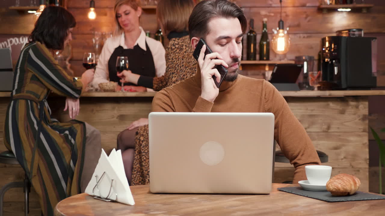 hombre trabajando en una computadora portátil en un café