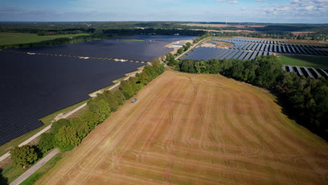 agricultural field after harvest and huge solar power panels electricity farm in poland aerial view