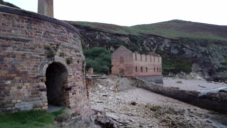 panning across abandoned porth wen industrial brickwork factory and furnace ruins on anglesey coast