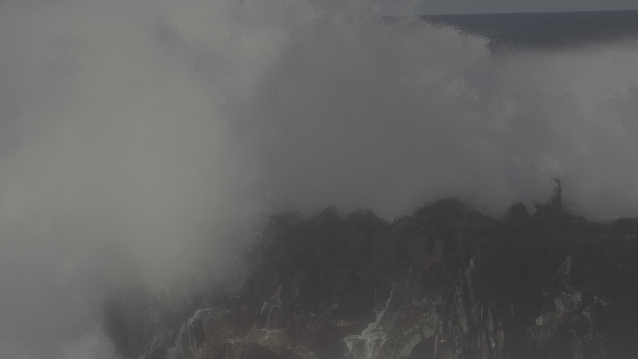 강력한 파도가 바위가 있는 해안에 부히고