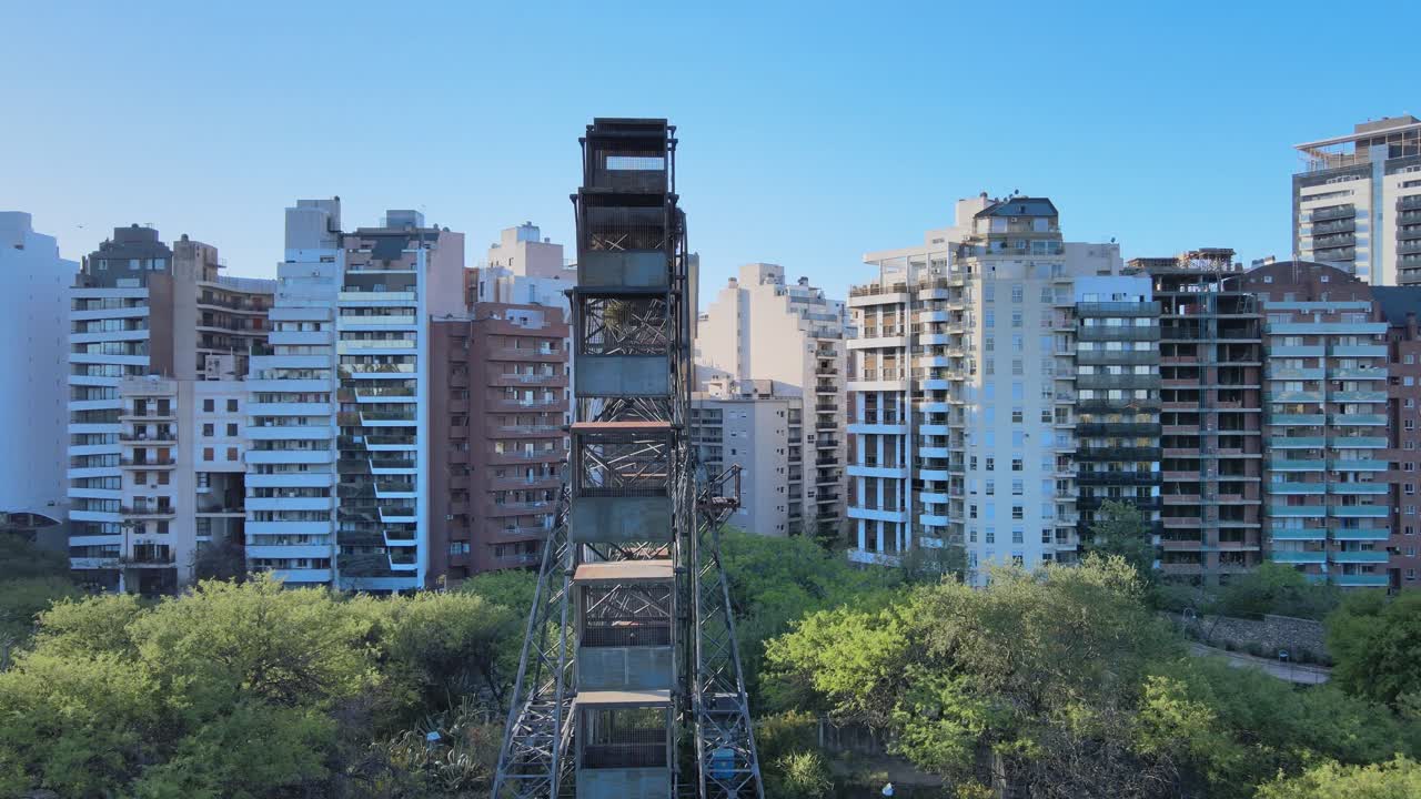 toma panorámica lenta que captura los detalles rústicos de la rueda de la fortuna de todo el mundo contra filas de apartamentos residenciales a lo largo de la av.