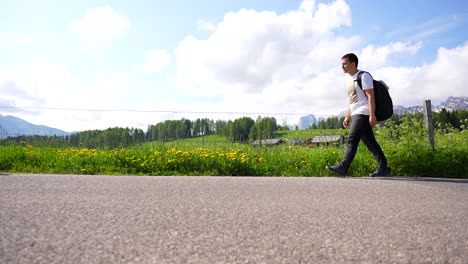 man walking on an asphalted road in green alpe di siusi, italy