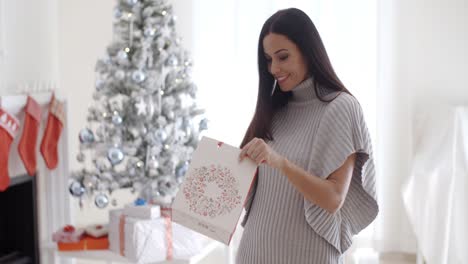 young woman opening a christmas gift bag