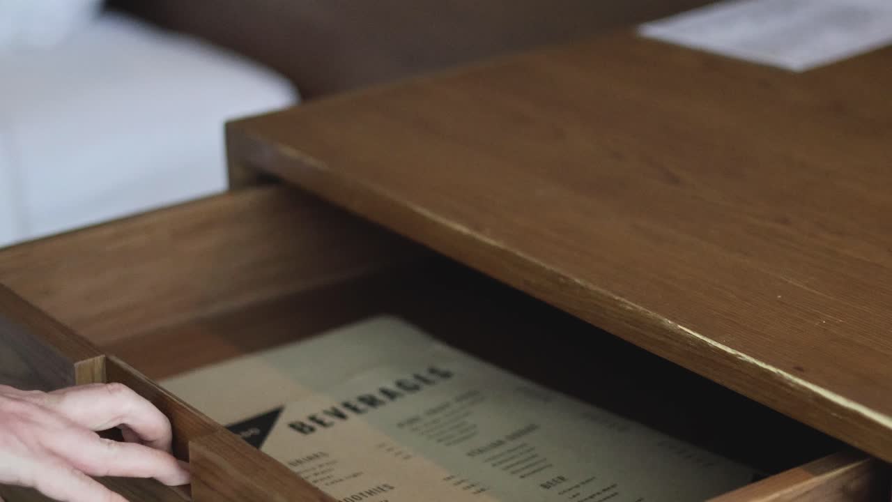 Hand interacting with a wooden drawer
