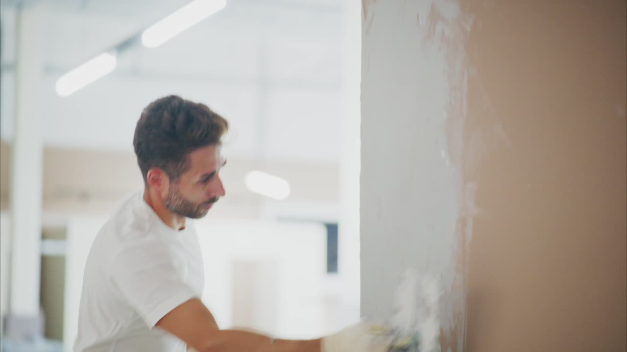 A Skilled Craftsman Applying Finishing Touches to a Smooth Wall Surface with Precision Tools, Showcasing the Art of Interior Decoration in a Modern Space
