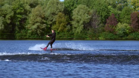 Wakeboarder-making-tricks-on-water.-Sportsman-wakeboarder-jumping-through-wave