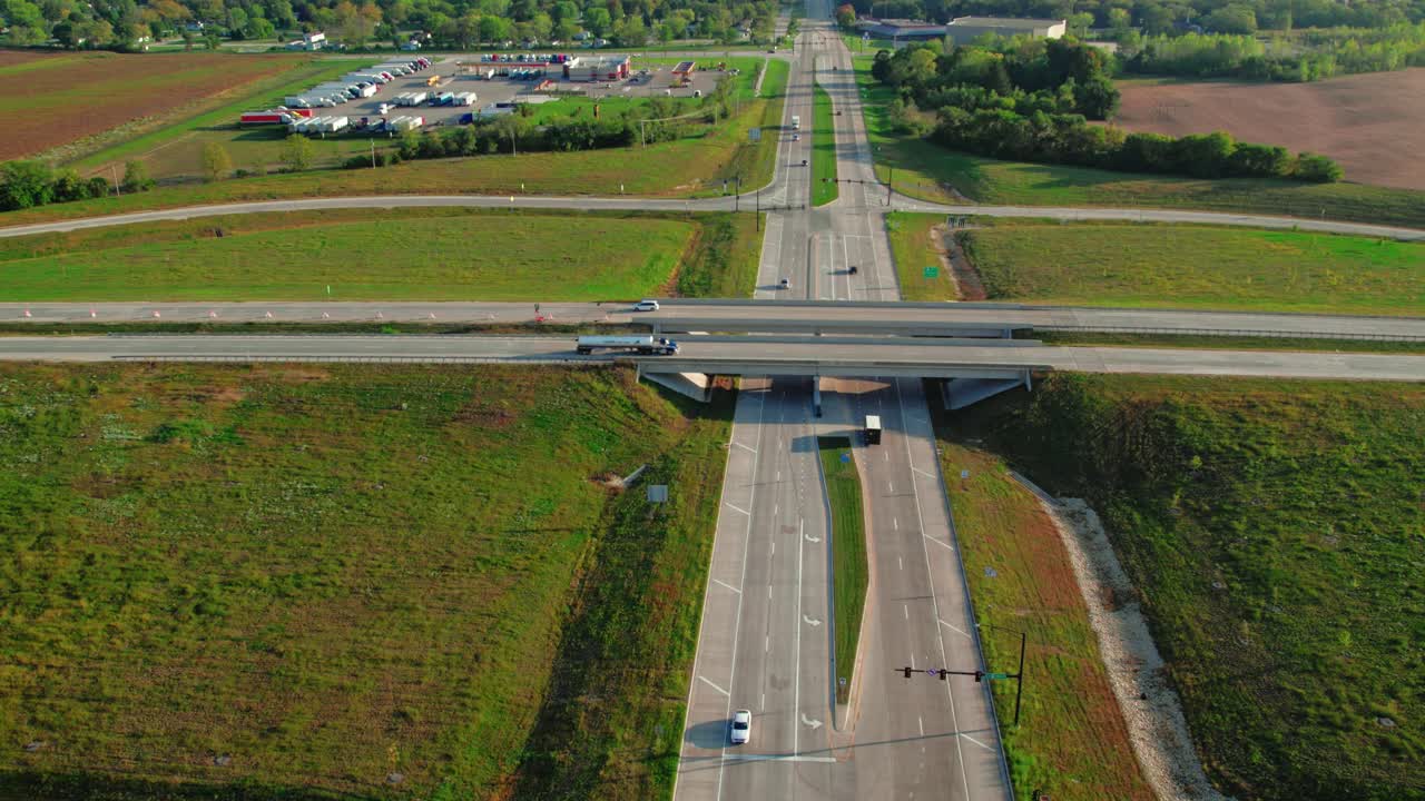 세미 트럭  ⁇ 커 가 다리 를 건너고, 왼쪽 구석 에 트럭 운전자 가 휴식 을 하고, 연료 를 채우거나 샤워 를 하는 큰 트럭 정류장