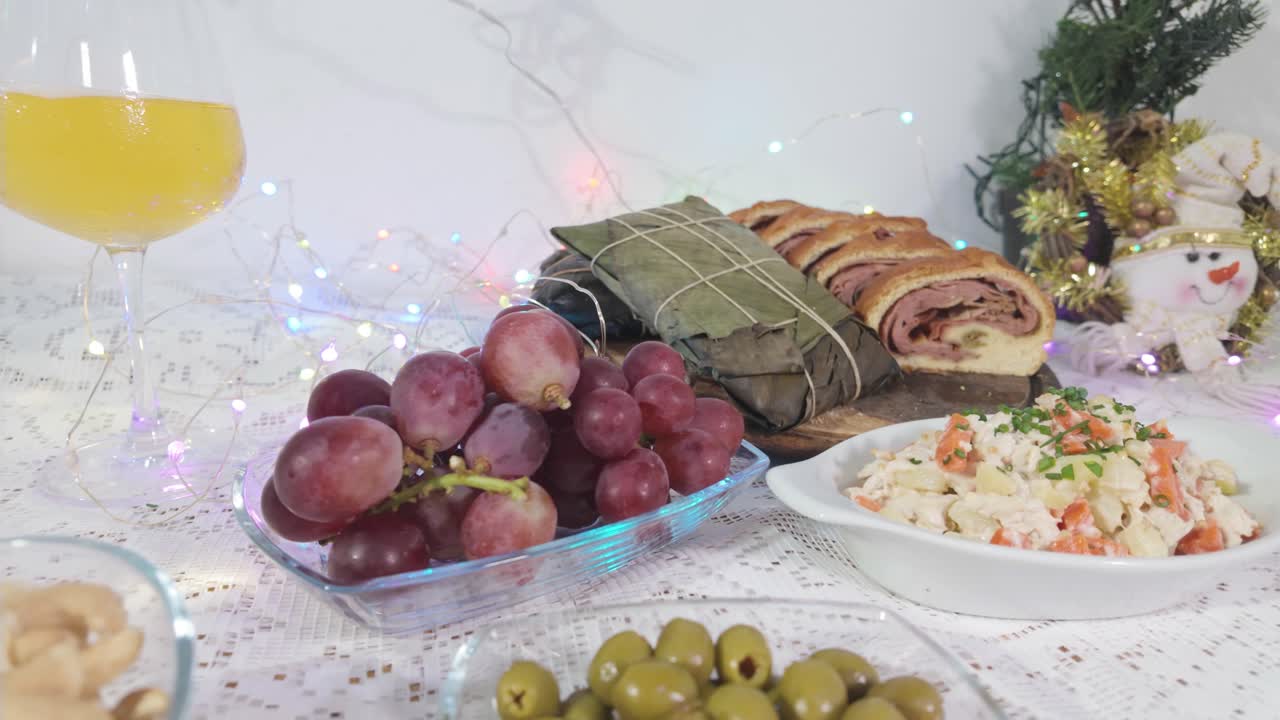 Cibo natalizio venezuelano: hallacas, pan de jamón e uva sul tavolo.