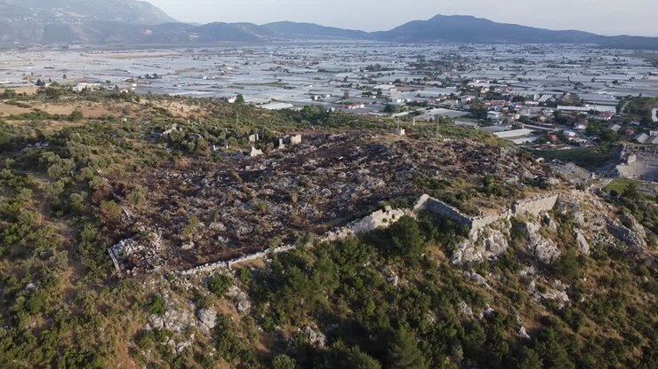 Drone panorerer fra venstre mod højre over ruinerne af Sillyon og en moderne tyrkisk by beliggende i Antalya-provinsen, Tyrkiet