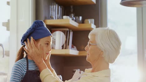 la abuela ajustando la gorra de la niña chef y besándola en la frente 4k 4k