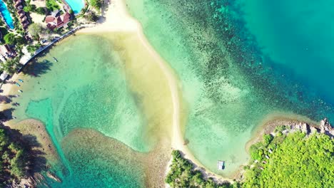 peaceful lagoon with coral reefs and rocks under calm crystal water near holiday resort in front of exotic beach in thailand