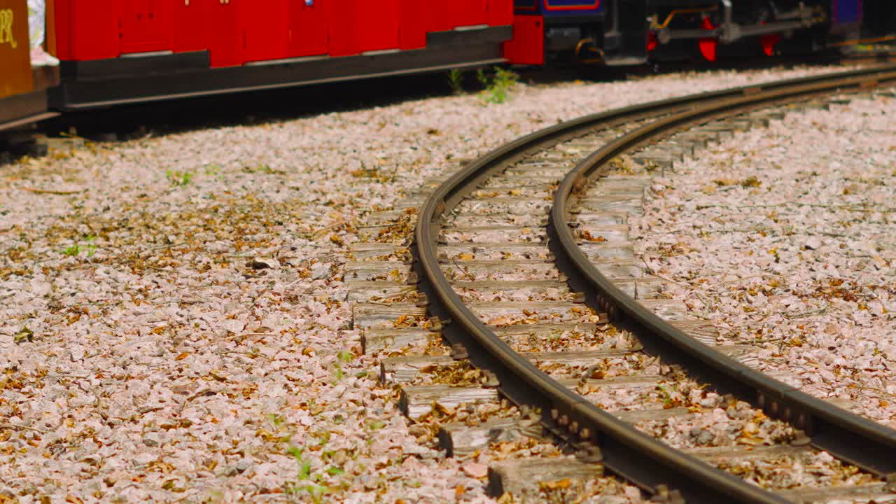 Slow Motion View of Narrow Gauge Train Tracks as Coal Locomotive Slowly Moves Along Bend on Rails