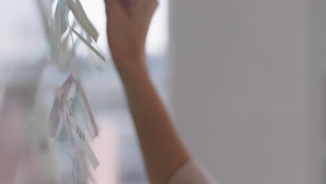 close up business woman using sticky notes brainstorming ideas problem solving with creative mind map planning strategy in office working on solution