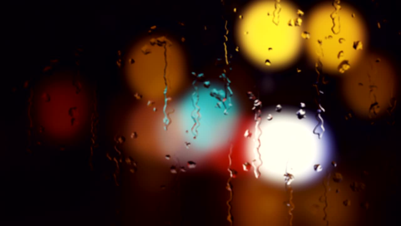 luces de la ciudad por la noche mientras la lluvia cae sobre el vidrio