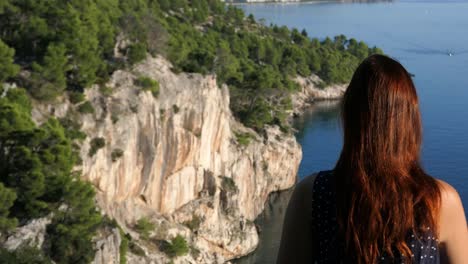 woman sitting on top of mountain edge and looking inspirational mountain sea view