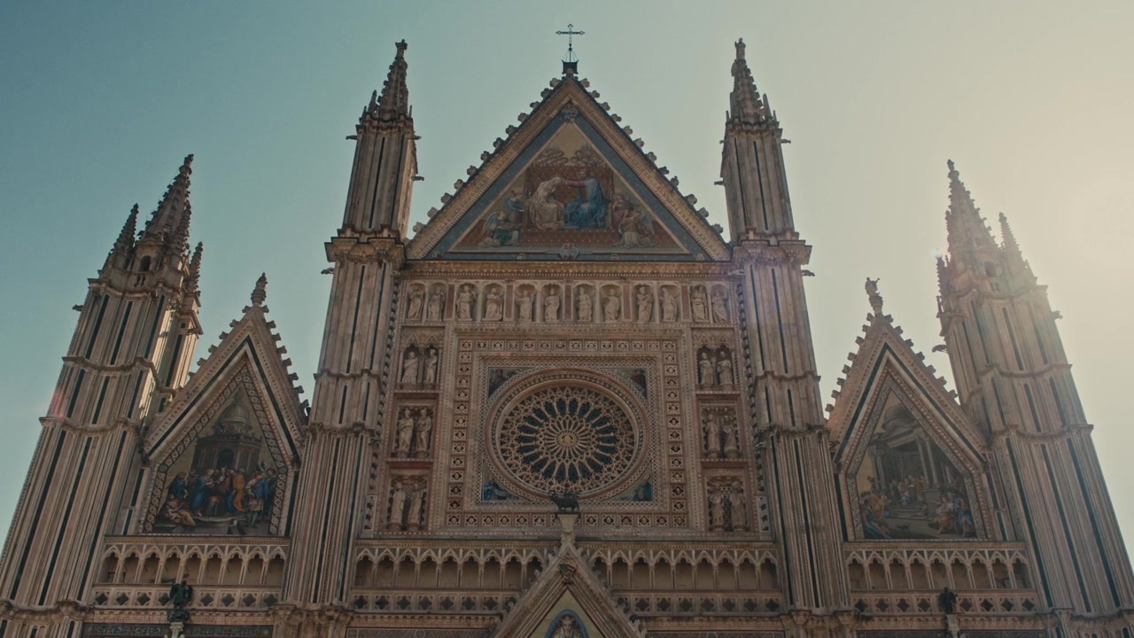 Vista en ángulo bajo de la fachada gótica de la Catedral de Orvieto con rosetón.