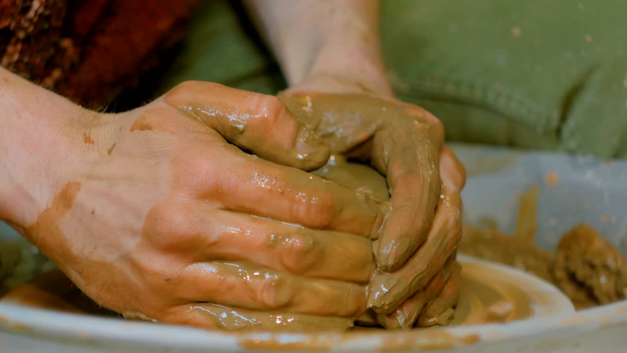 un alfarero profesional que trabaja con arcilla en la rueda del alfarero