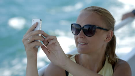 mujer tomando una selfie con un teléfono inteligente en el barco