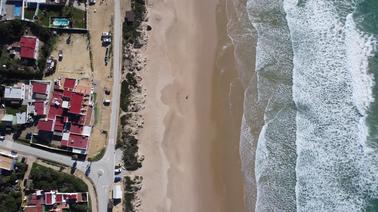 hermosas olas en una playa bonita con algunas calles y casas