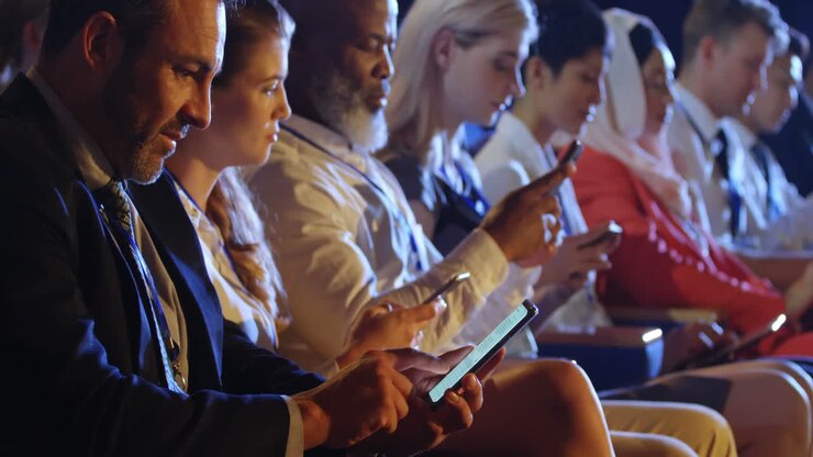 Business people using mobile phone while sitting on seats in auditorium 4k