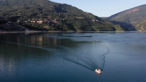 a small boat crossing a beautiful, calm lake on a sunny morning near debar in macedonia