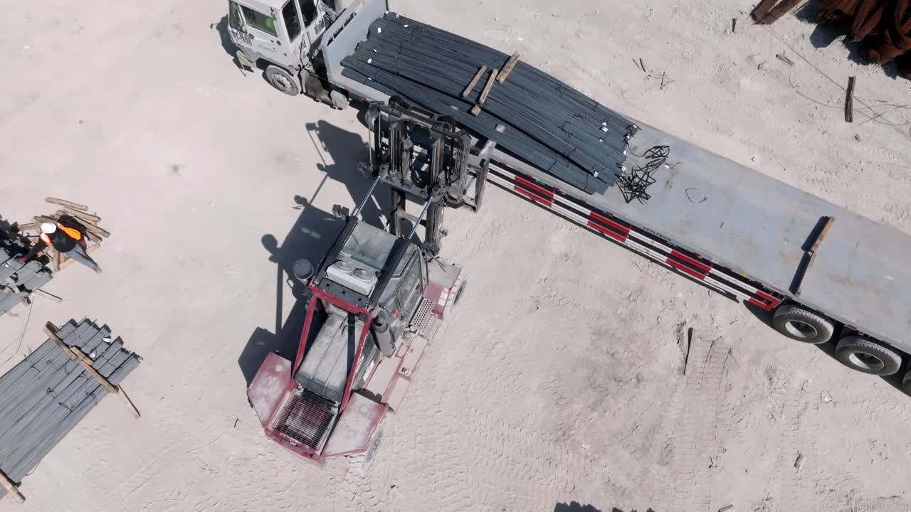 철강 공장 에서 강철 판 을 들어 올리는 포크리프트 를 바라보는 공중 전망