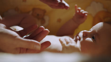 baby interacting with parent's hands