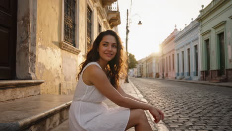 young woman enjoying sunset on a cobblestone street in a historic city