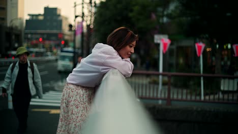 woman leaning on bridge railing at twilight
