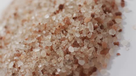 video of pile of himalayan pink salt on white background