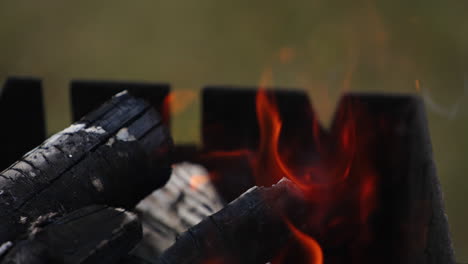 Burning firewood in fireplace. Close up of glowing wood embers for barbecue