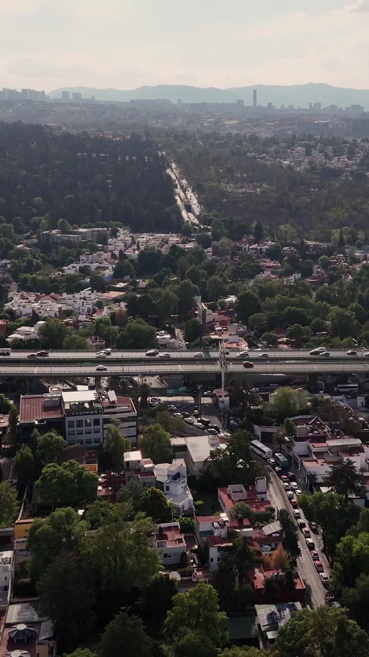 Dikey modda, CDMX sokakları, caddeleri ve trafiğinin ağır çekim havadan görünümü.