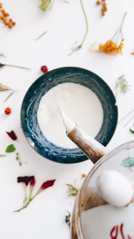 pouring milk into a cup with floral arrangement