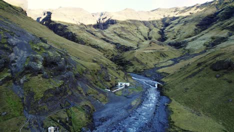 thermal bath seljavallalaug, scenic volcanic icelandic nature, aerial dolly out