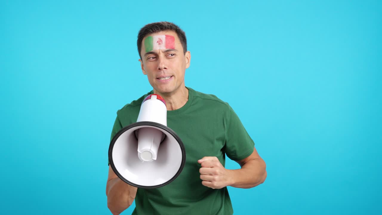 Excited man with mexican flag on face using a megaphone