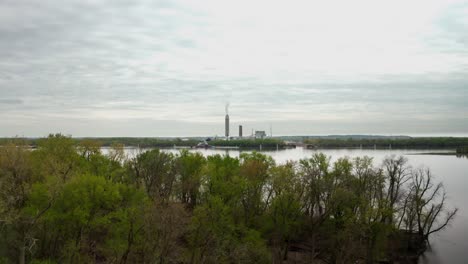 drone shot of coal power plant from across a big river and small island