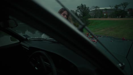 woman with flowers by a vintage car