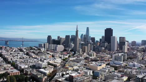 drone footage of san francisco starting near fisherman's wharf area flying towards the financial district with light clouds and blue skies