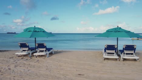 Toma-Panorámica-De-Sillas-De-Playa-Y-Sombrillas-En-Un-Día-Claro.