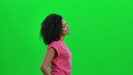 side view of young female african american considering something. black woman with curly hair poses on green screen in the studio. close up. slow motion ready 59.97fps