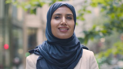 portrait of muslim businesswoman outdoors standing in front of city offices 5