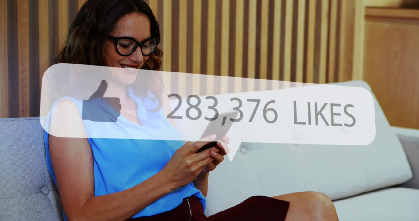 Animation of social media like notification over smiling caucasian woman using smartphone